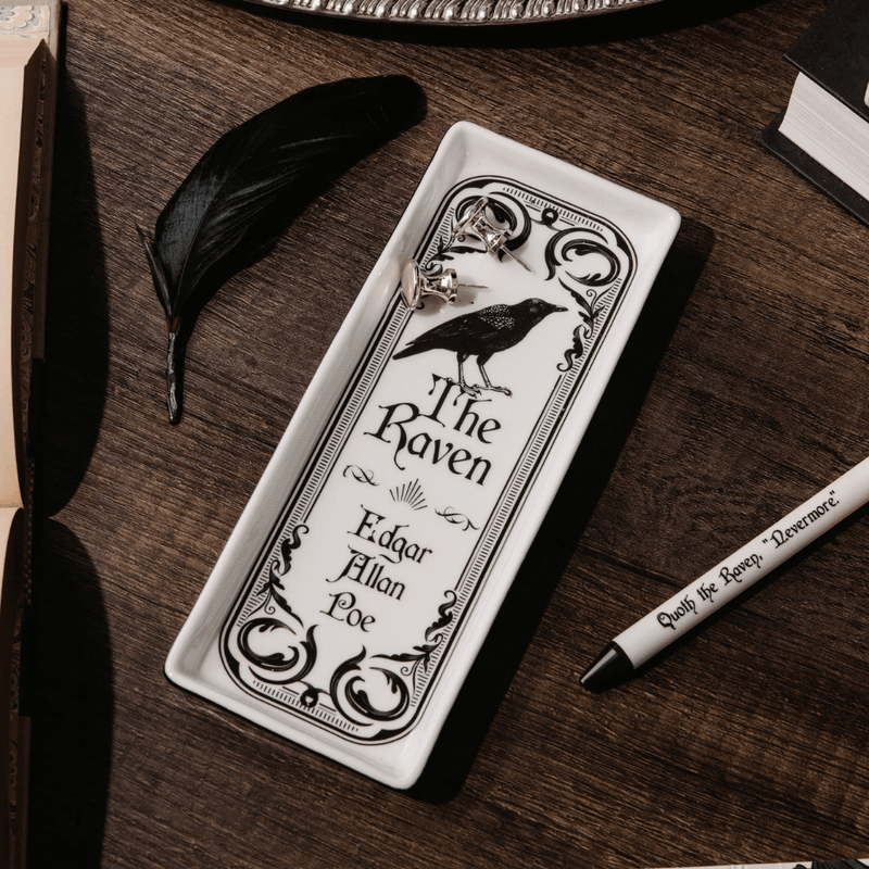 The Raven ceramic trinket tray holding silver jewellery on a wooden desk