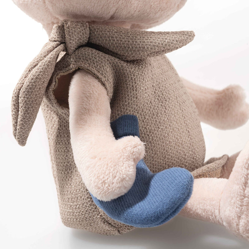 Close-up of Steiff Dobby’s tunic tie and blue sock held in hand, textured fabric detail.