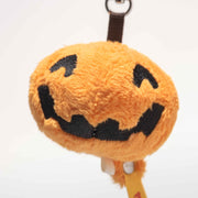 Close-up of soft orange pumpkin keyring showing embroidered jack-o-lantern details