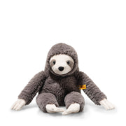 Steiff Sanny Sloth plush toy sitting with long arms, grey fluffy fur and yellow ear tag, front view.