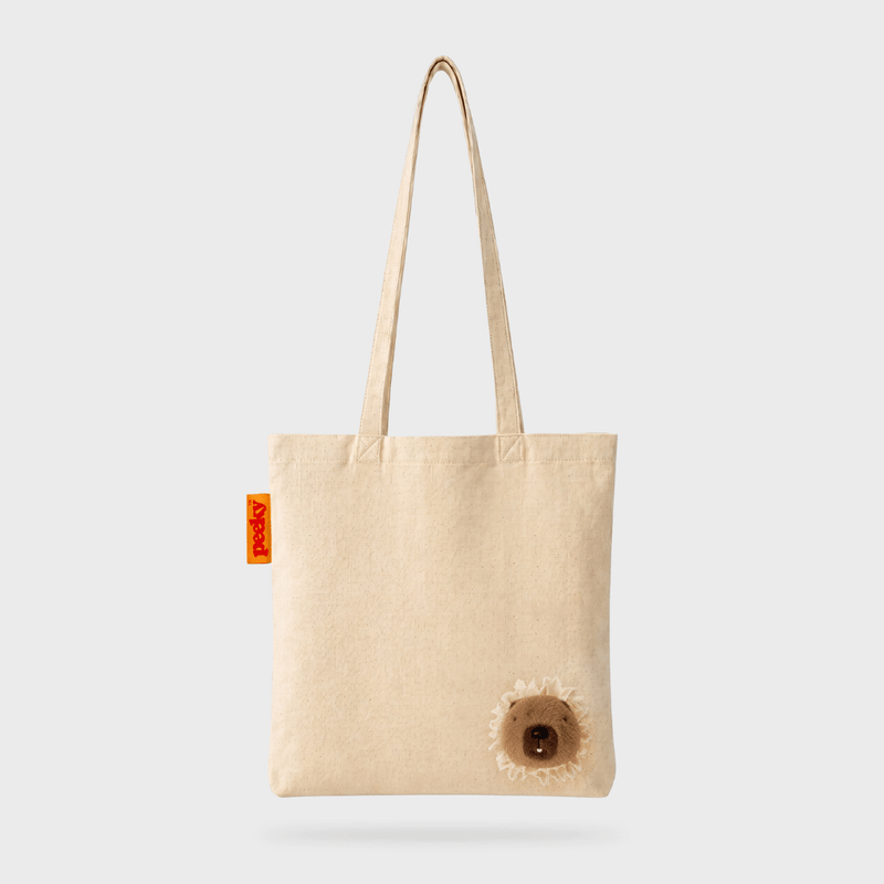 Front product view of the SUCK UK Peeky Capybara tote bag, a cream canvas shopper with long straps and three-dimensional brown plush capybara.