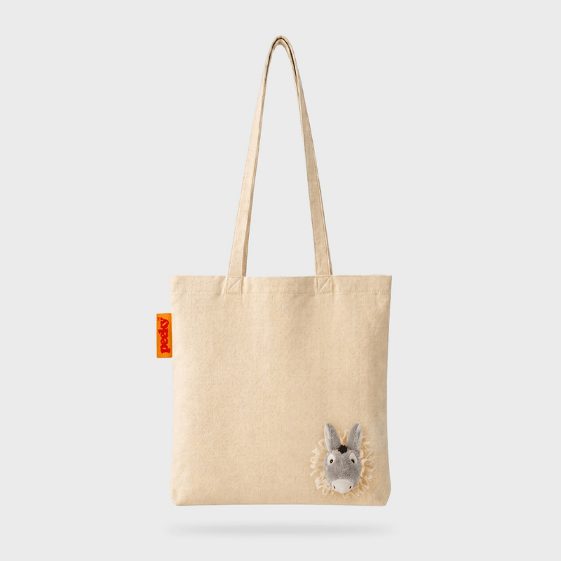Full front view of the SUCK UK Peeky Donkey natural cotton canvas tote bag with shoulder straps and a three-dimensional grey donkey head.