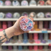 Sugared Blossom wax melt pot held in hand with colourful wax melt display in the background