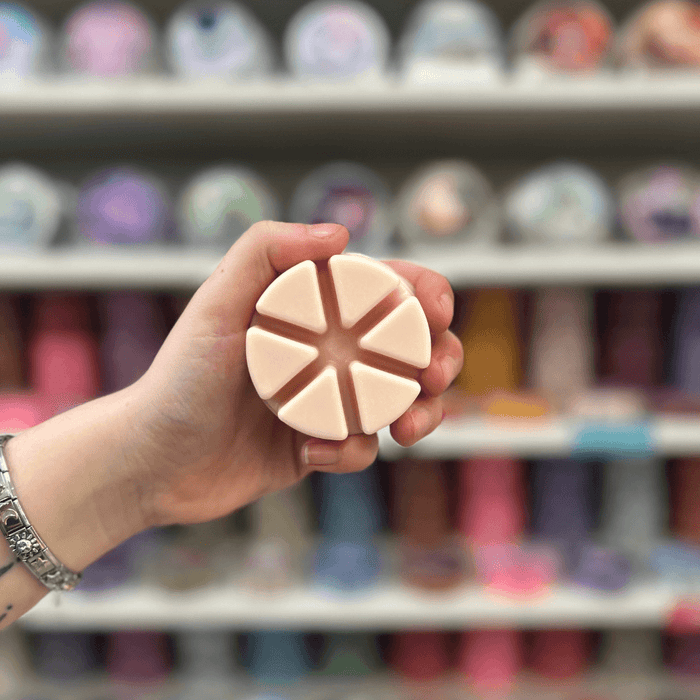 Sugared Blossom wax melt segments held in hand with colourful wax melt display in the background
