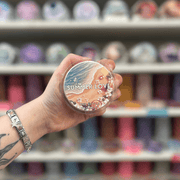 Summer Love wax melt pot held in hand with colourful wax melt display in the background