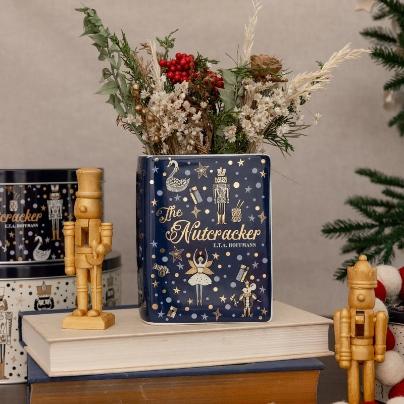 The Nutcracker small book vase styled with winter foliage beside wooden nutcrackers