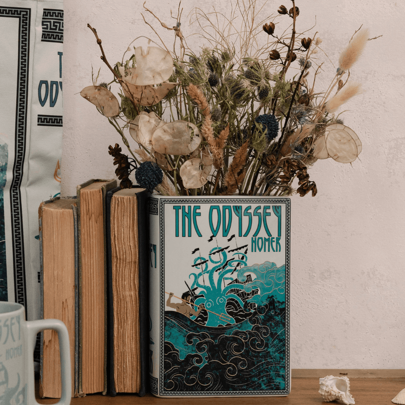The Odyssey large book vase styled on a shelf with dried flowers and books
