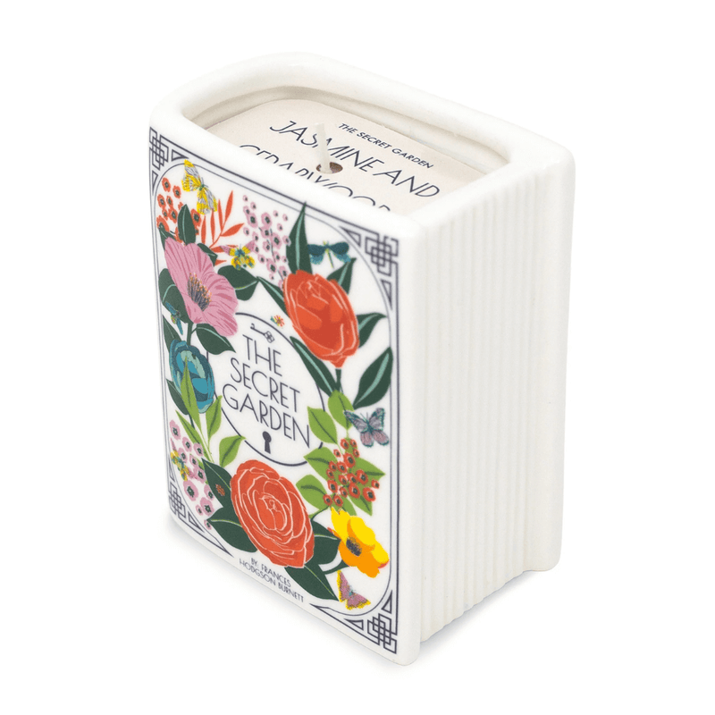 Angled top view of The Secret Garden book shaped candle showing wax label and floral book cover.