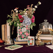 Wide styled scene featuring The Secret Garden book shaped candle with floral book vase and decorative accessories.