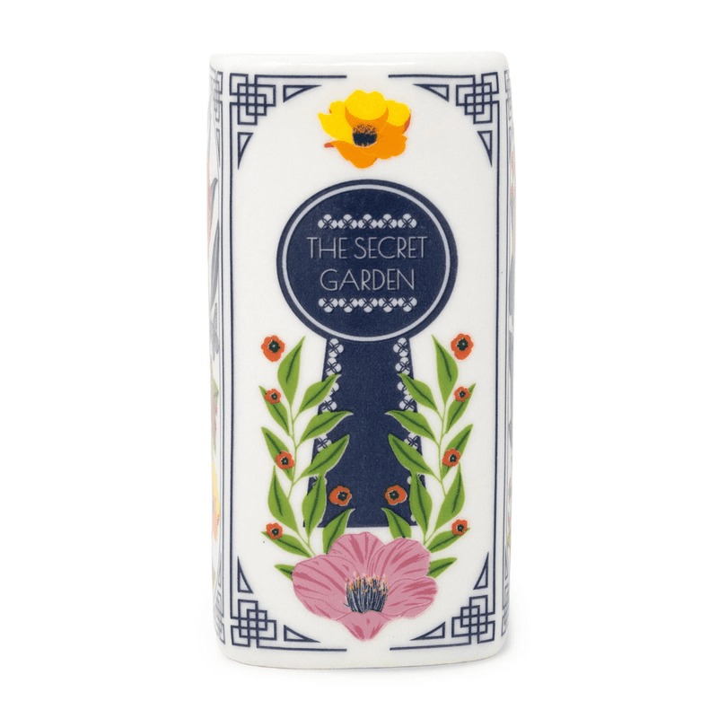 Close-up of The Secret Garden candle spine with keyhole artwork and floral details.