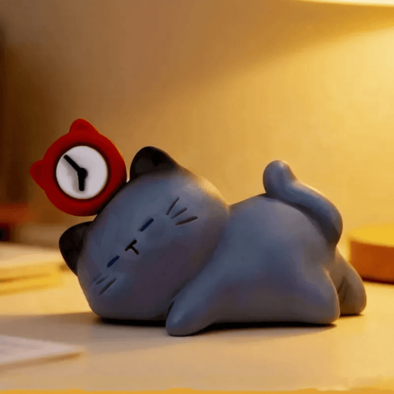 Sleepy Kitty lying beside a red alarm clock from the ThingsWoo The Cat Come blind box series