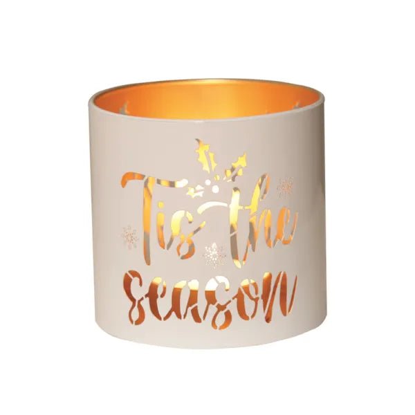 Round white and gold Tis the Season tealight candle holder shown glowing