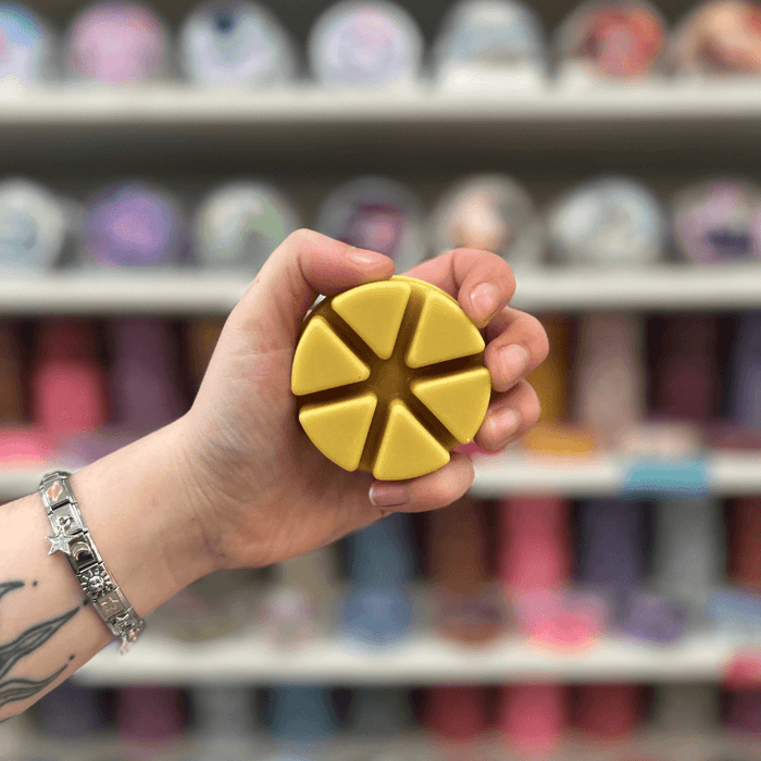 Toasty Marshmallows wax melt pot held in hand with colourful wax melt display in the background