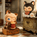 Assorted MOFFY’s Magic Furry Mewky blind box figures displayed on luggage and furniture in a tailoring shop scene
