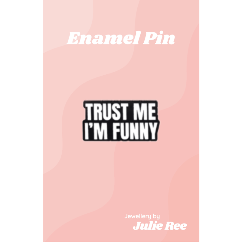 Black enamel pin with bold white text reading Trust Me I’m Funny, displayed on a pink backing card.