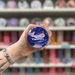 Twilight Rainfall wax melt pot held in hand with colourful wax melt display in the background
