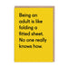 Yellow funny greeting card with black text about adulting being like folding a fitted sheet; A6, blank inside, kraft envelope by Twin Pines