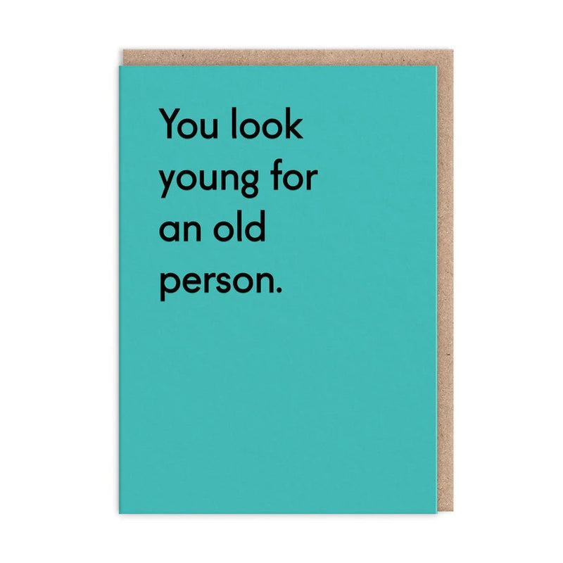 Teal funny greeting card with black text: You look young for an old person; A6, blank inside, kraft envelope by Twin Pines