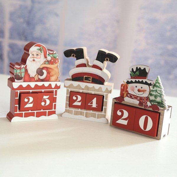 Lifestyle trio of wooden chimney advent calendars including upside-down Santa design on a tabletop.