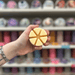 Pale yellow segmented wax melt held in hand in front of a colourful wax melt display