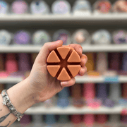Vintage Bookstore wax melt segments held in hand with colourful wax melt display in the background