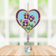 Heart-shaped Violet Crystal Suncatcher with purple violet motif and faceted prism heart catching sunlight in a window

