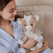 Child holding Warmies Goat plush toy on a sofa