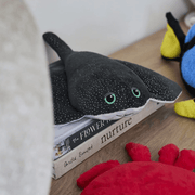 Warmies Manta Ray plush toy displayed on books