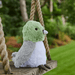 Warmies Pigeon plush toy sitting on a garden swing