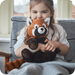 Child holding Warmies Red Panda heatable plush toy