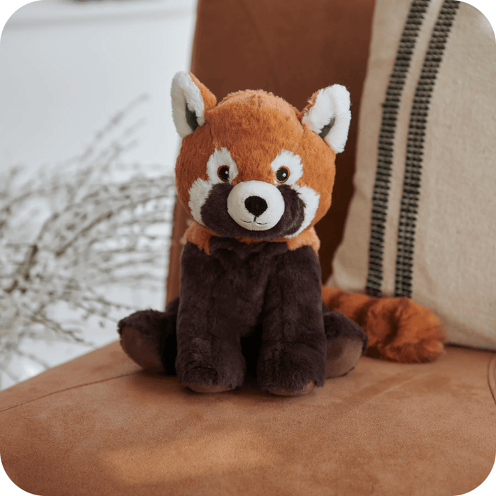 Warmies Red Panda heatable plush toy sitting on a chair