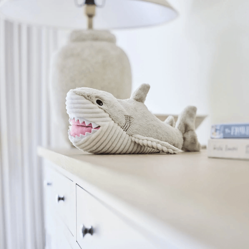 Warmies Shark plush toy styled on a bedroom cabinet