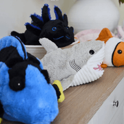 Warmies Shark plush toy displayed on a shelf with sea creature plush toys