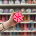 Watermelon Lemonade wax melt segments held in hand with colourful wax melt display in the background