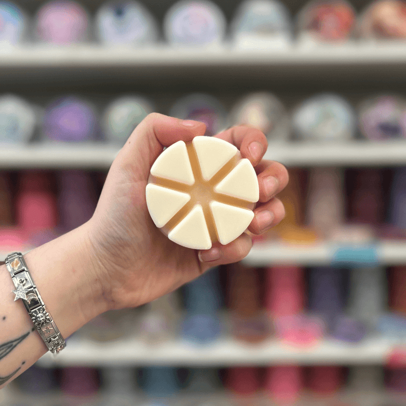 Wedding Day wax melt segments held in hand with colourful wax melt display in the background