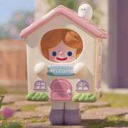Welcome Mascot RiCO figure dressed as a pastel house holding a “WELCOME” sign
