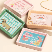 Pink ceramic trinket dish with Home Is Where The Cat Is design shown in a styled flat lay with other mini trinket dishes.
