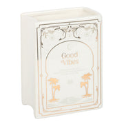 Upright white book shaped vase with Good Vibes cover design