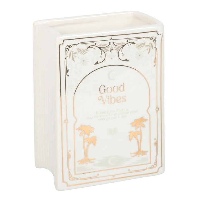 Upright white book shaped vase with Good Vibes cover design