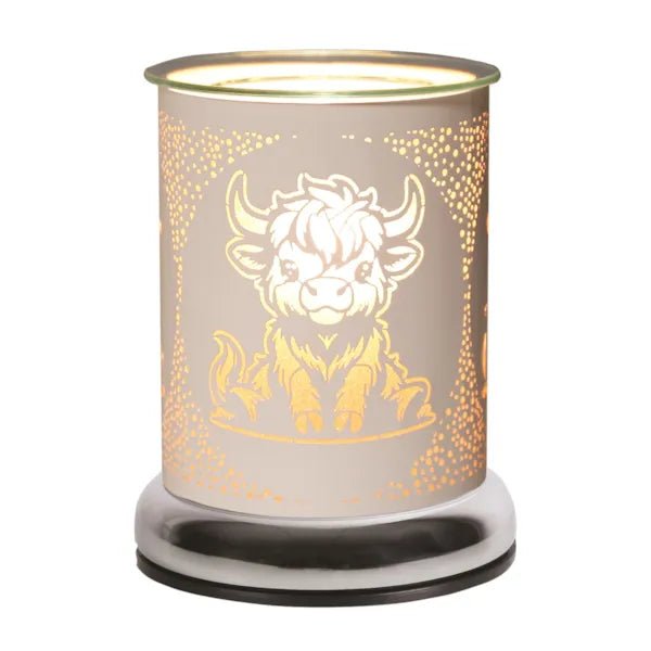 White Highland Cow wax melt burner lit with warm glow