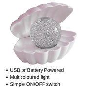 White pearlescent LED clam lamp with clear glitter pearl and text listing USB or battery powered features.