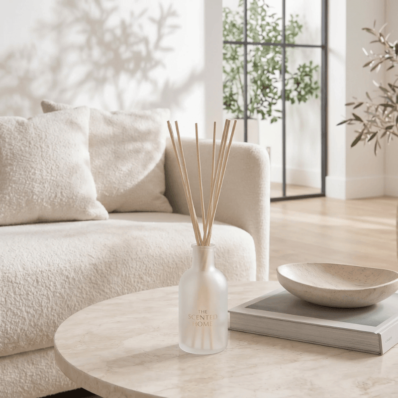 The Scented Home reed diffuser styled on a neutral living room coffee table
