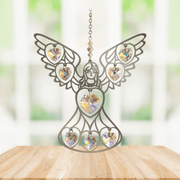 Handmade angel aurora borealis crystal suncatcher displayed on a wooden table in front of a bright window

