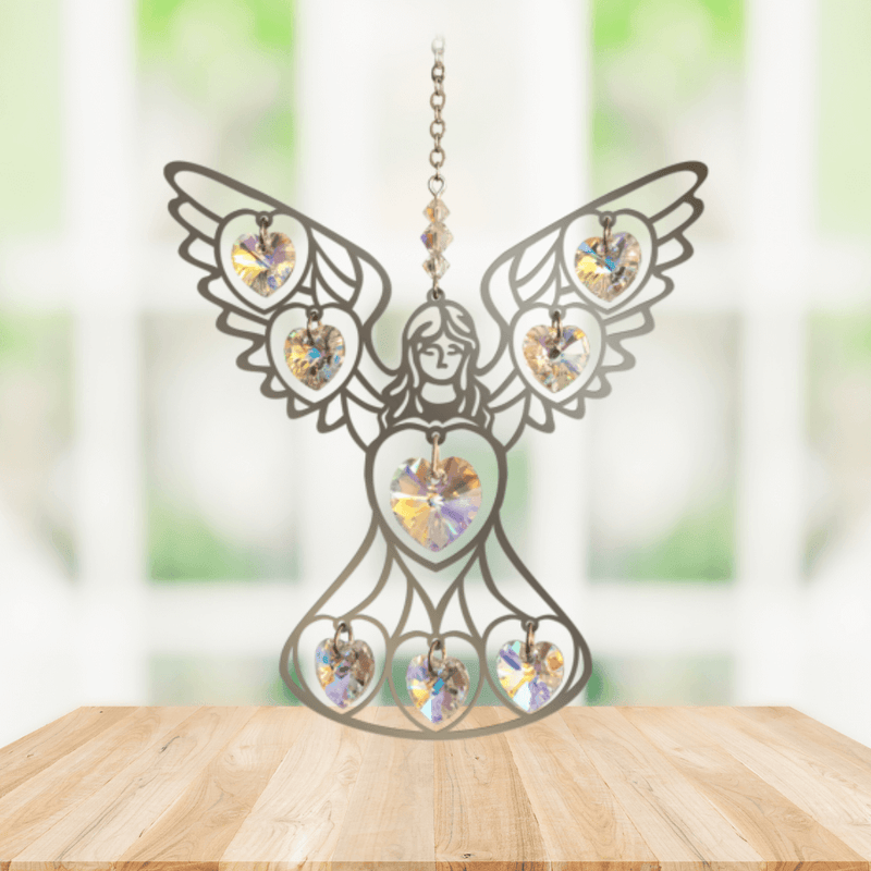 Handmade angel aurora borealis crystal suncatcher displayed on a wooden table in front of a bright window

