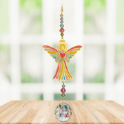 Handmade angel-heart crystal suncatcher displayed on a wooden table in a bright window

