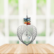 Handmade Angel Wing Heart crystal suncatcher displayed on a wooden table in front of a bright window

