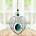 Emerald angel wing heart suncatcher with crystals hanging in a bright window