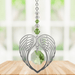 Peridot angel wing heart crystal suncatcher hanging in a bright window
