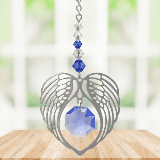Sapphire angel wing heart suncatcher with crystals hanging in a bright window