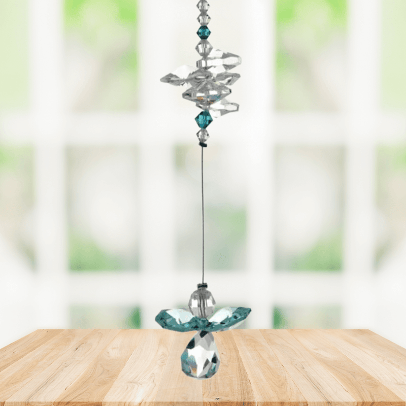 Blue zircon guardian angel crystal cascade suncatcher hanging in a bright window